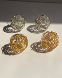 Interwoven orb statement earrings in gold and silver finishes.