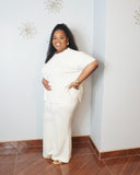 Plus size model wearing an oatmeal scuba knit matching set with a curved hem top and wide leg pants.