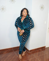 Plus size model wearing emerald illusion mesh bodysuit and fitted pants set front view with gold heels