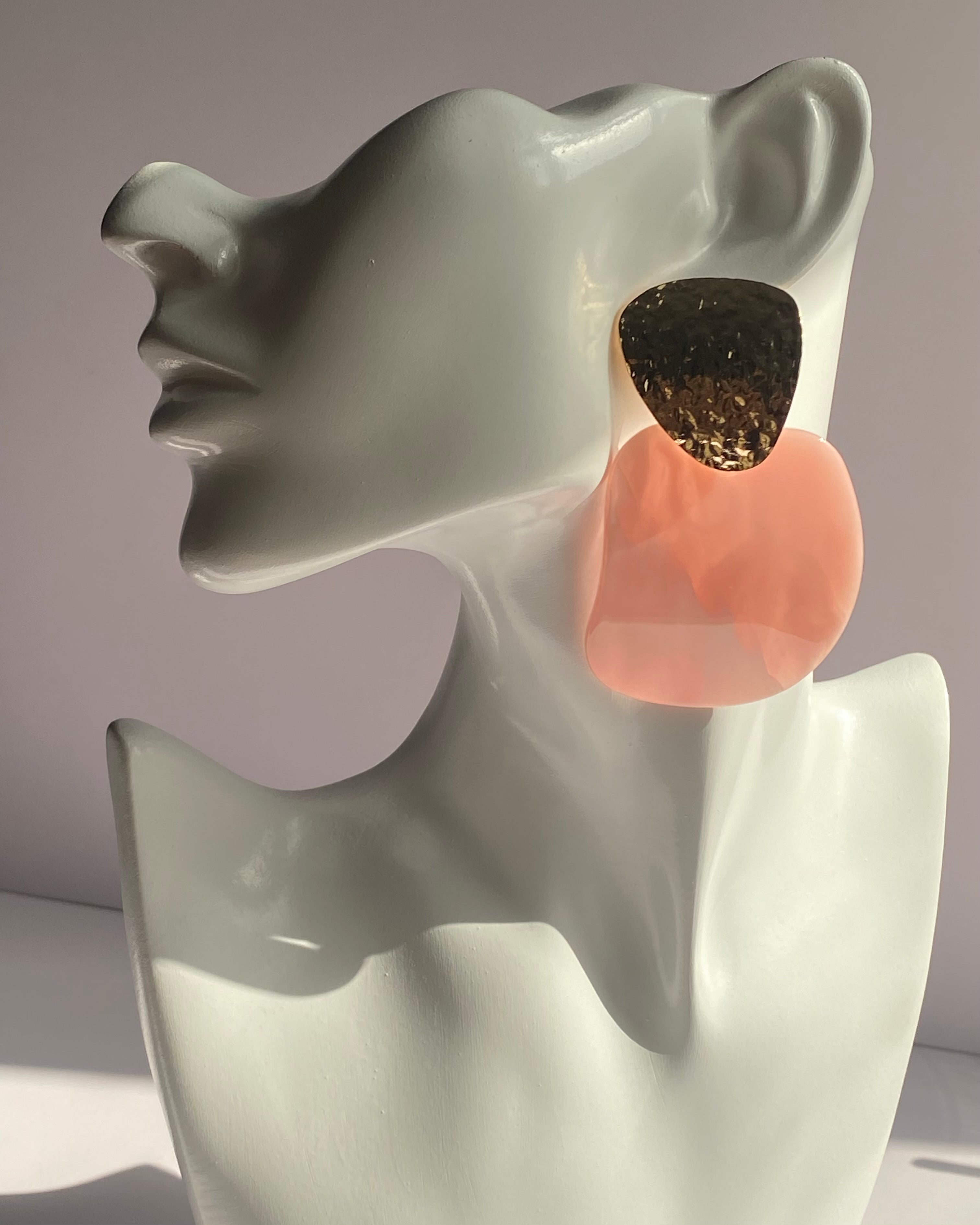 Oversized statement earrings featuring textured gold-tone studs with translucent resin drop pendants available in Peach Glow and Ivory Glow.
