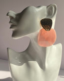 Oversized statement earrings featuring textured gold-tone studs with translucent resin drop pendants available in Peach Glow and Ivory Glow.