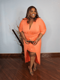 Plus size coral wrap midi dress with waist tie and high low hem styled with heels