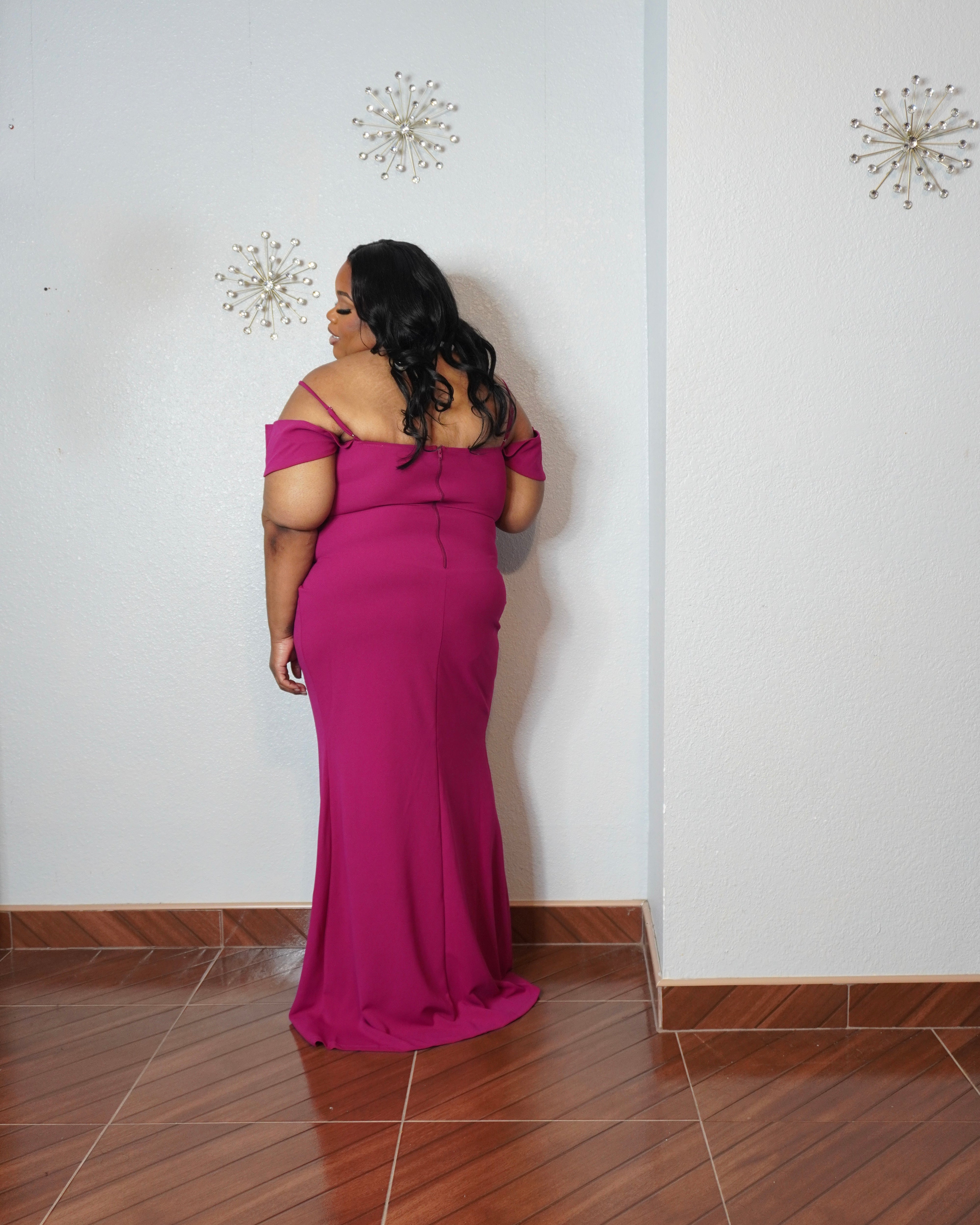 Curvy fashion model wearing glamorous magenta evening dress for weddings and formal events