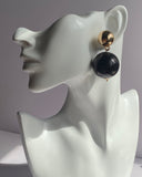 Gold ball drop statement earrings with glossy red and black sphere variations and polished gold-tone studs.