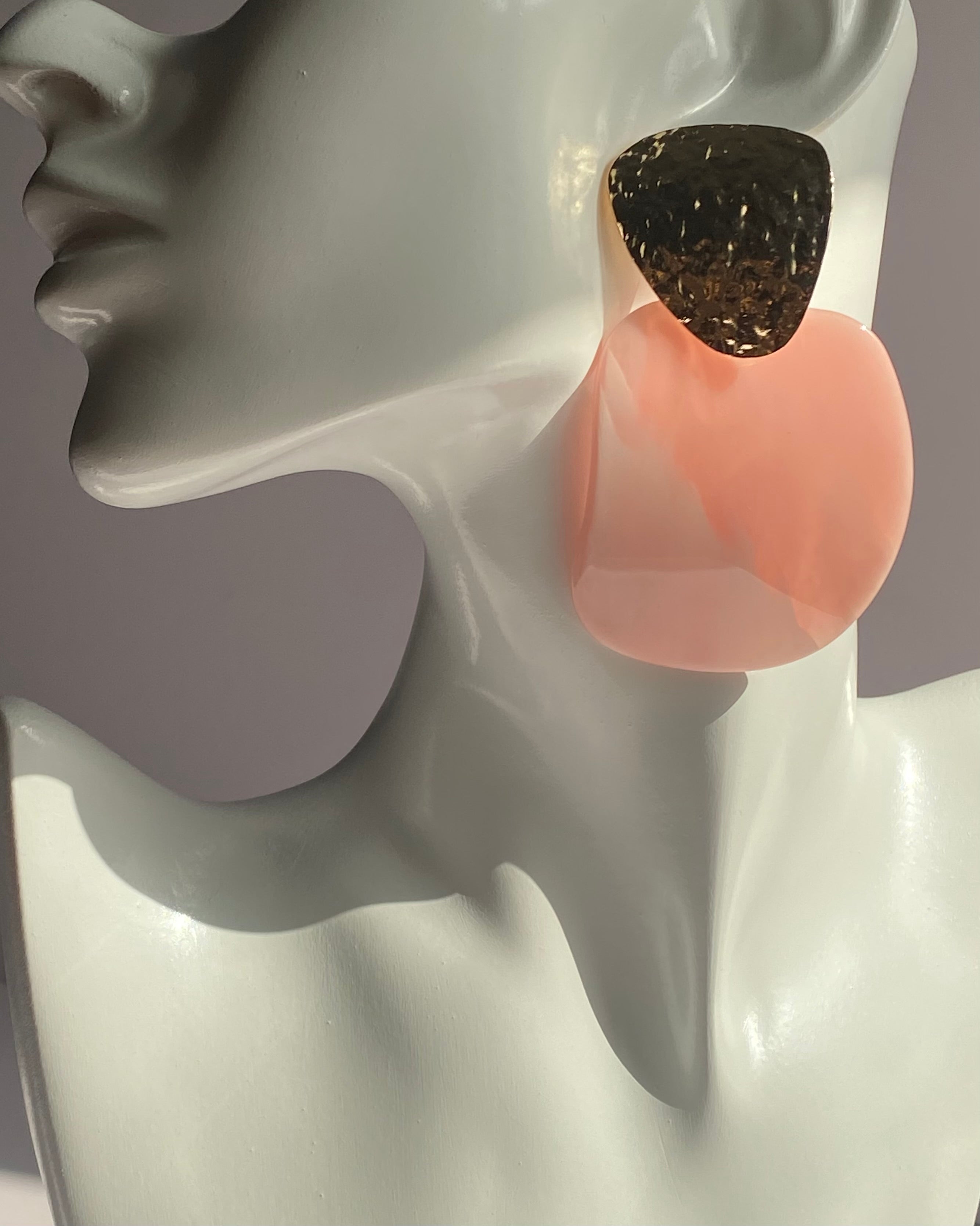 Oversized statement earrings featuring textured gold-tone studs with translucent resin drop pendants available in Peach Glow and Ivory Glow.