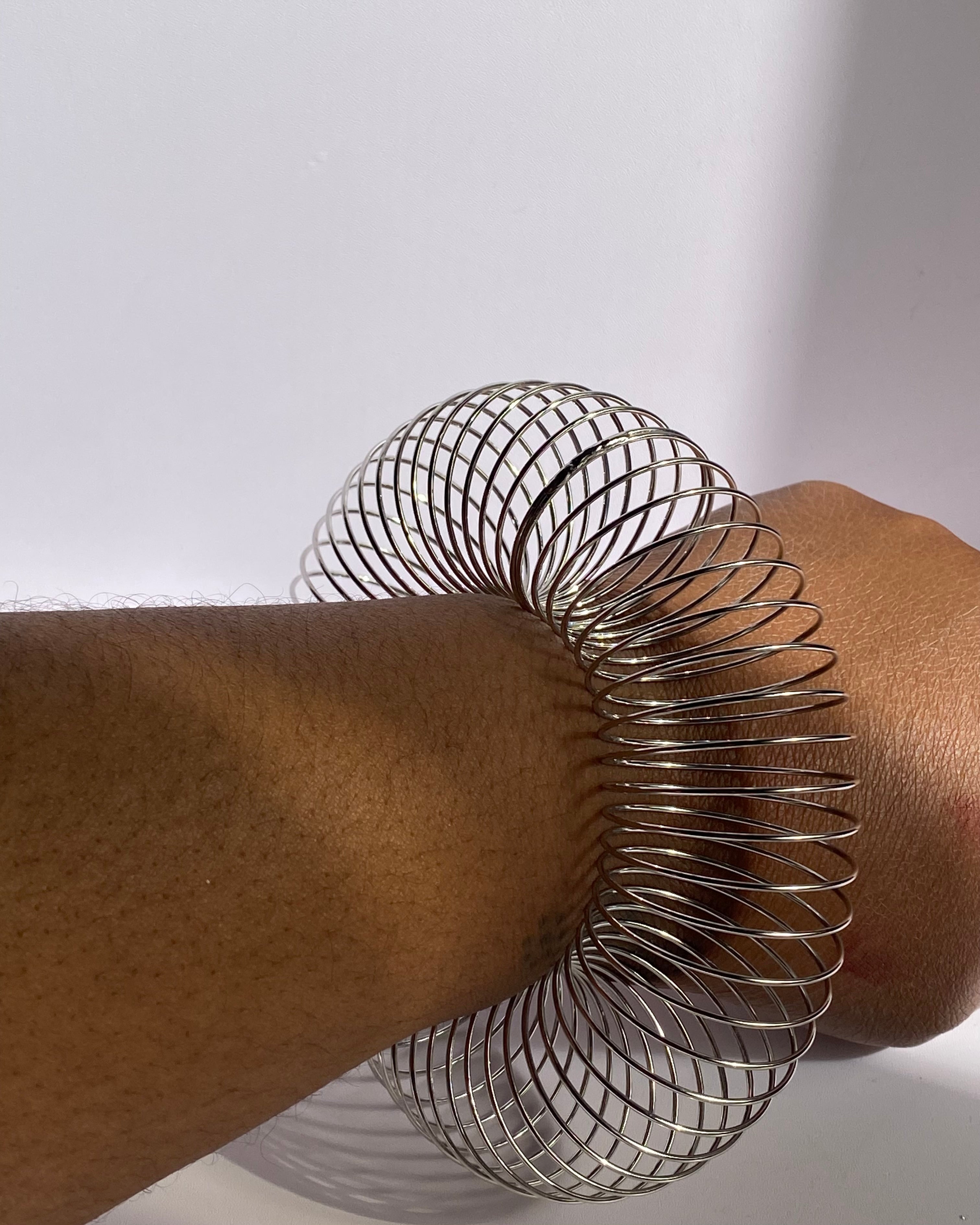 Silver minimalist wire coil bracelet worn closed for sleek everyday look