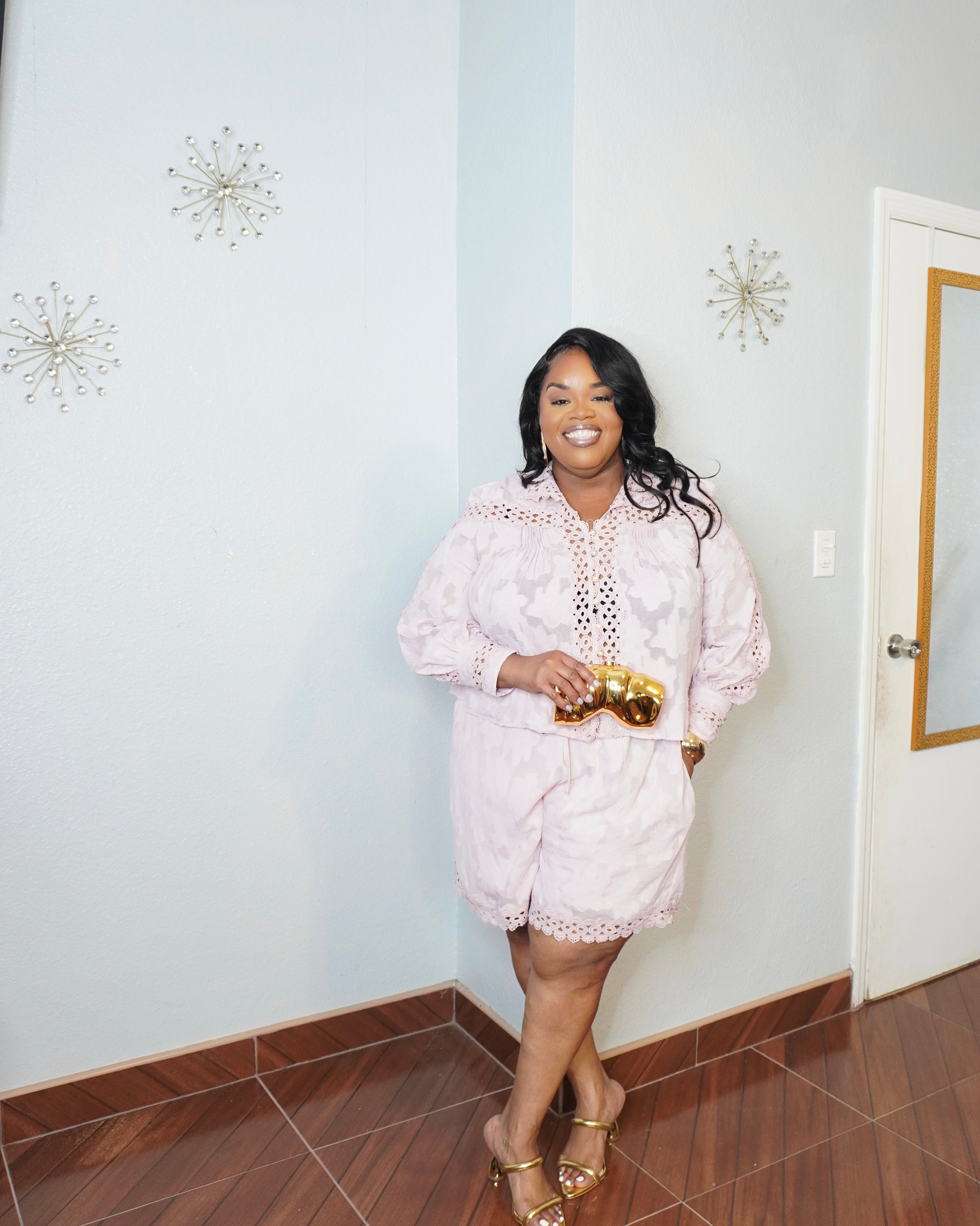 Plus size model in a blush textured two piece short set with lace trim, smiling angled pose