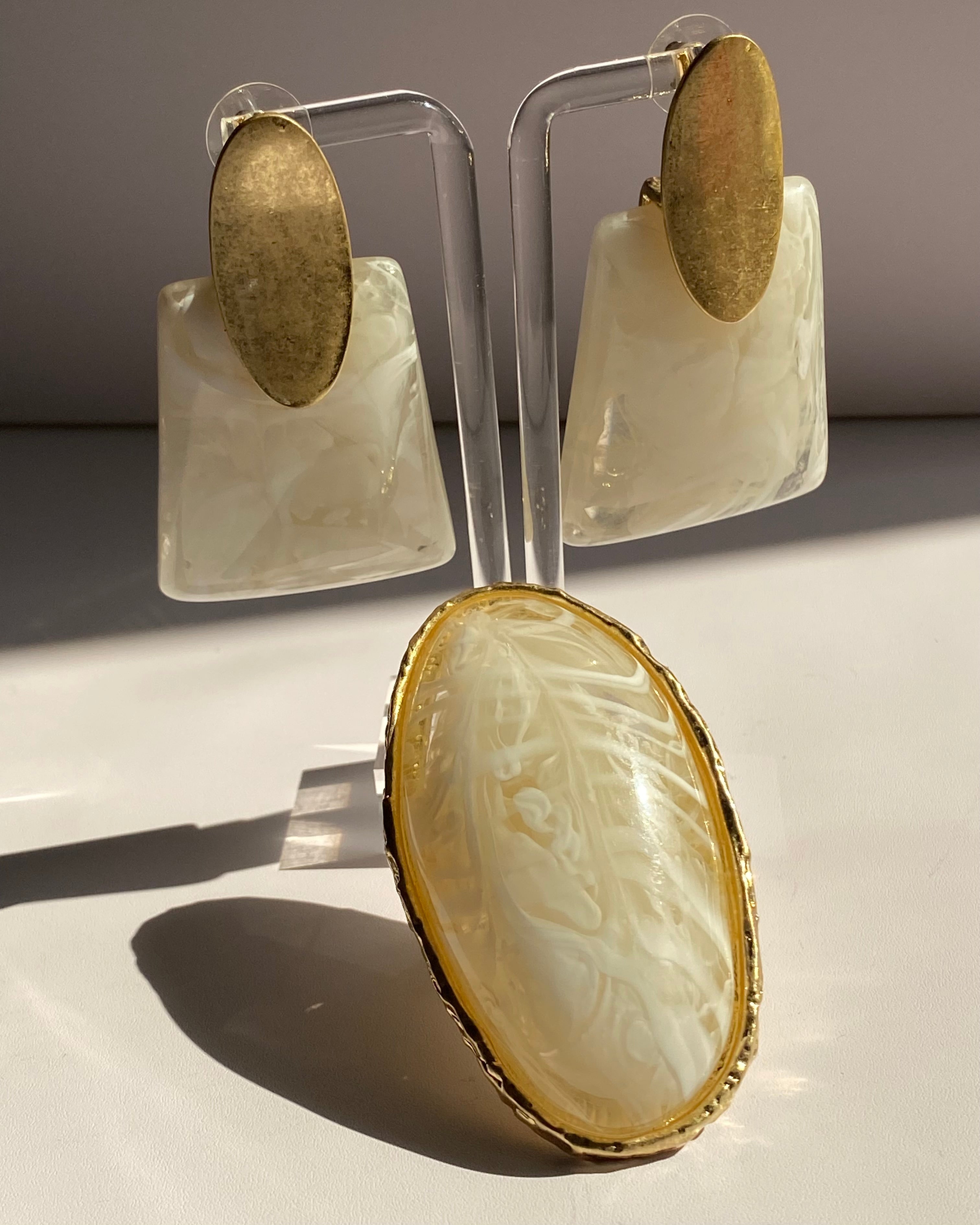 Ivory marbled resin statement earrings with brushed gold oval studs in a modern geometric design.