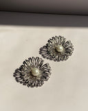 Pearl center sunburst stainless steel stud earrings available in gold and silver finishes.
