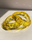 Transparent yellow faceted crystal statement bangle bracelet with reflective geometric detailing.