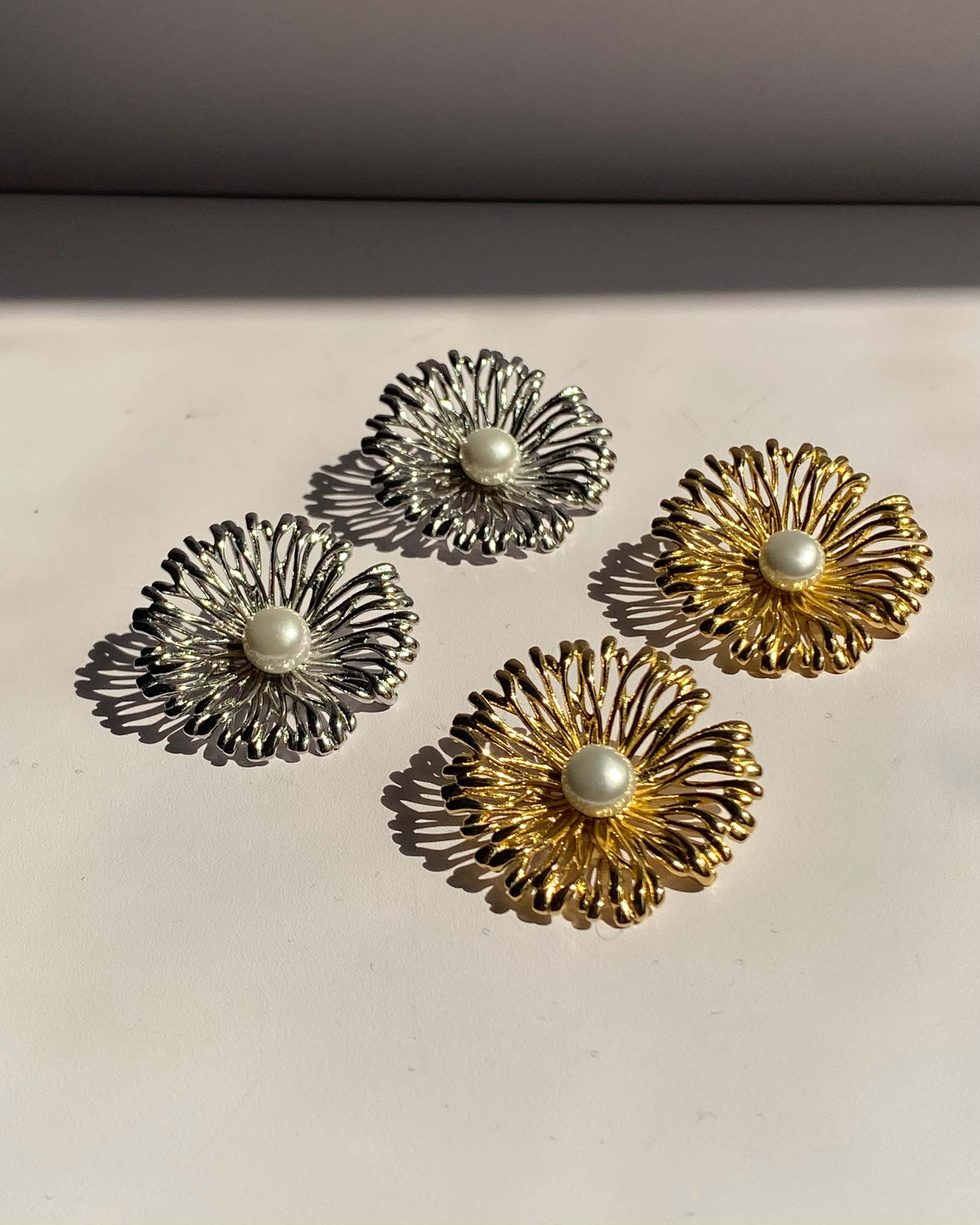 Pearl center sunburst stainless steel stud earrings available in gold and silver finishes.