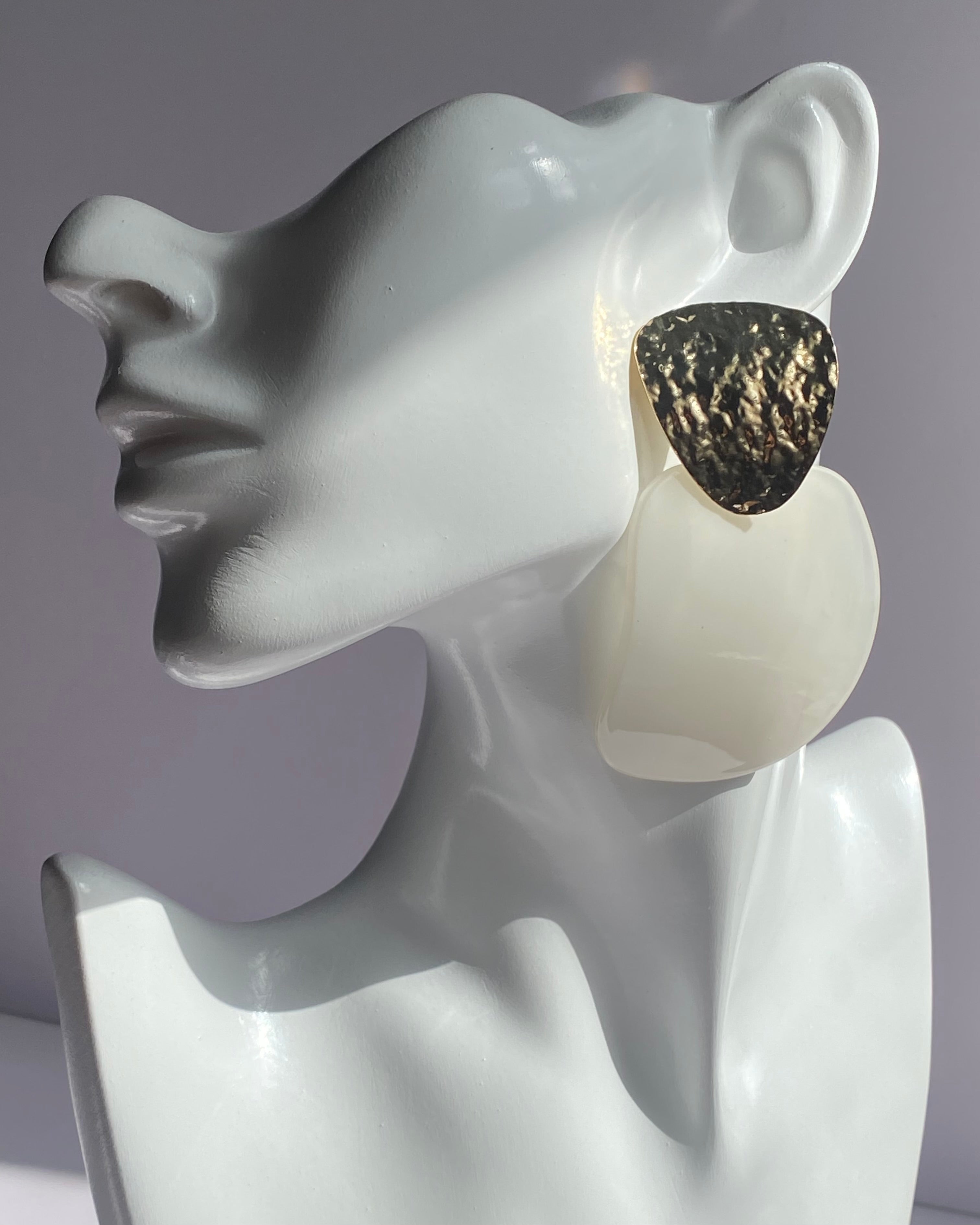 Oversized statement earrings featuring textured gold-tone studs with translucent resin drop pendants available in Peach Glow and Ivory Glow.