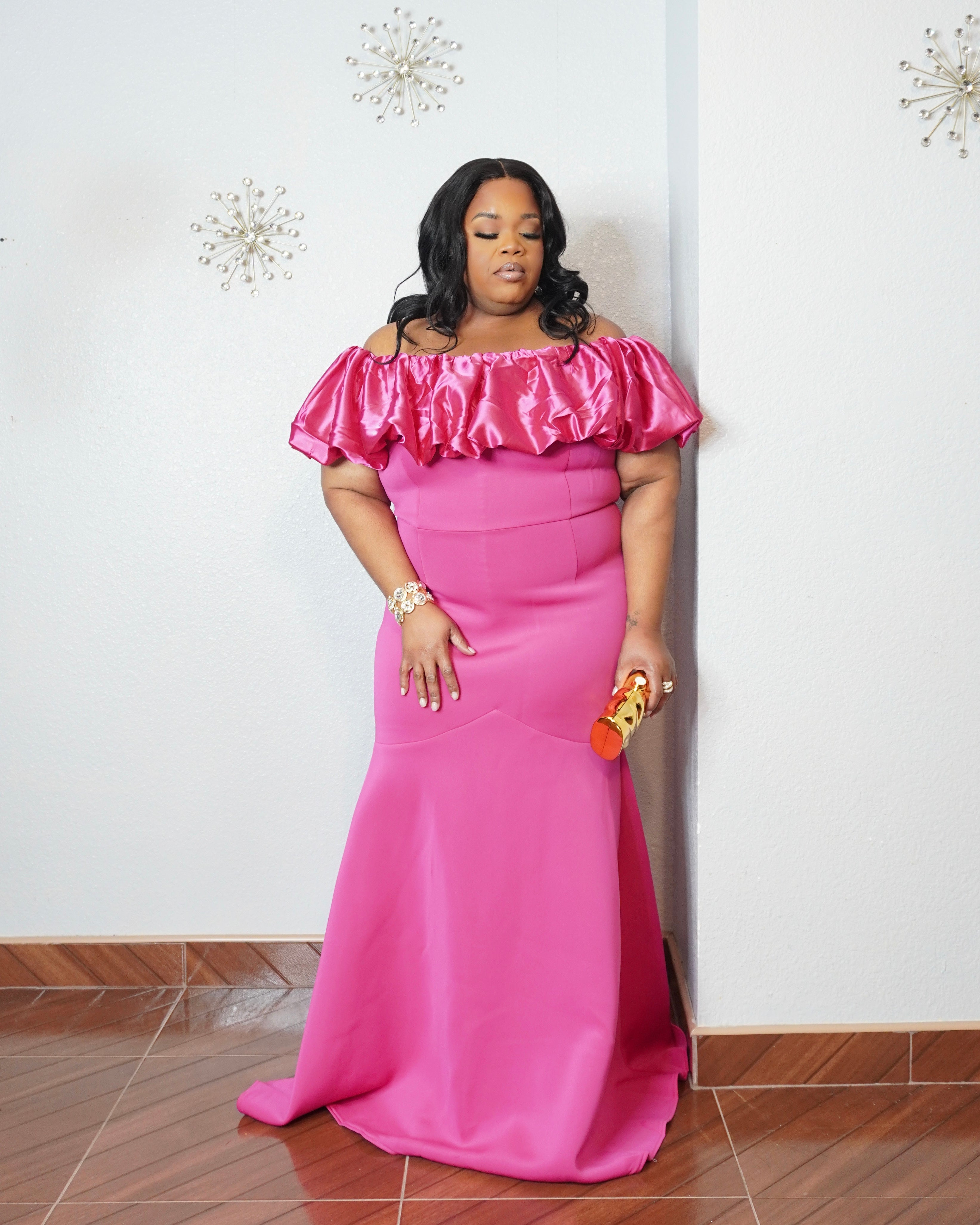Curvy woman modeling glamorous pink formal dress with satin ruffles