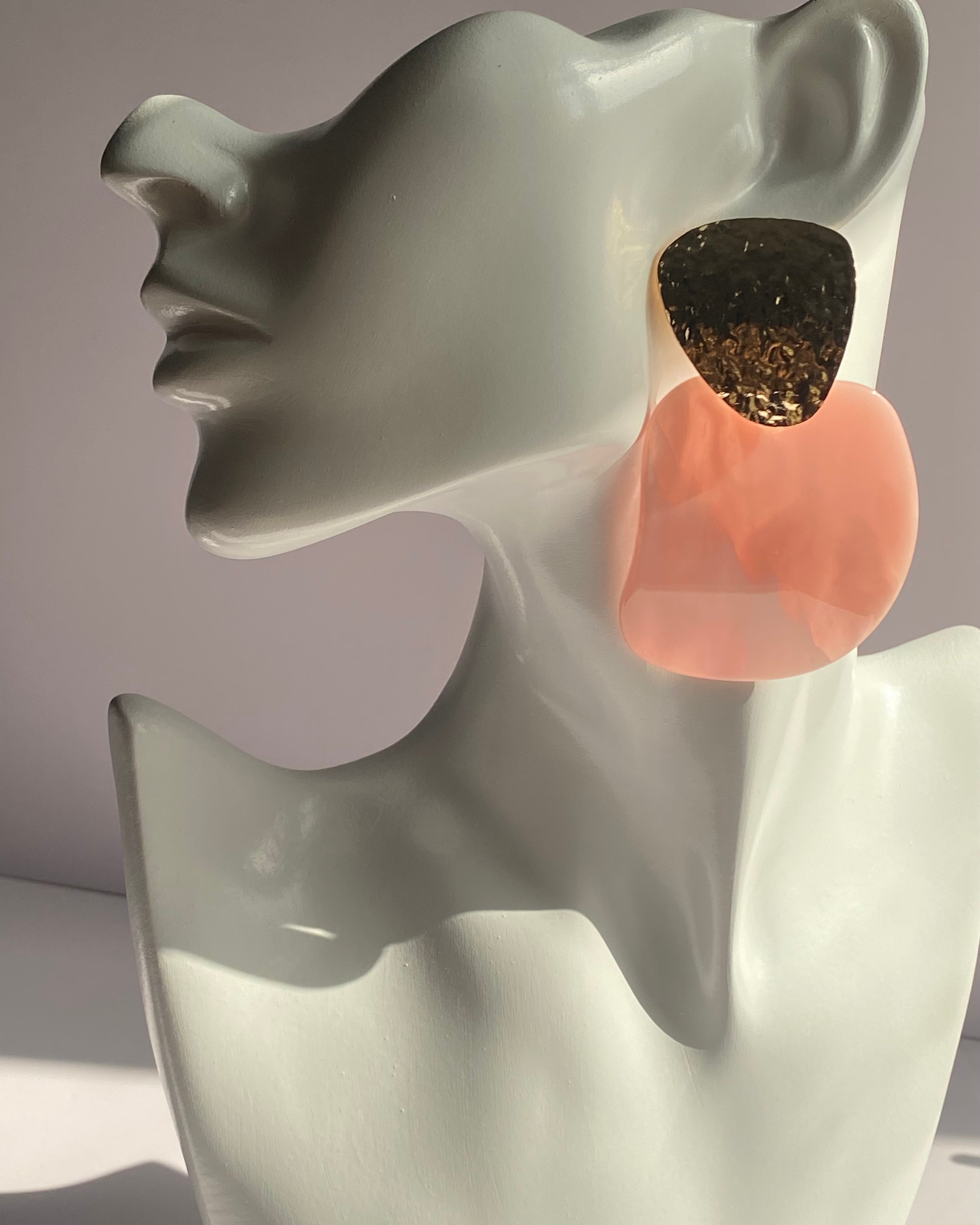 Oversized statement earrings featuring textured gold-tone studs with translucent resin drop pendants available in Peach Glow and Ivory Glow.